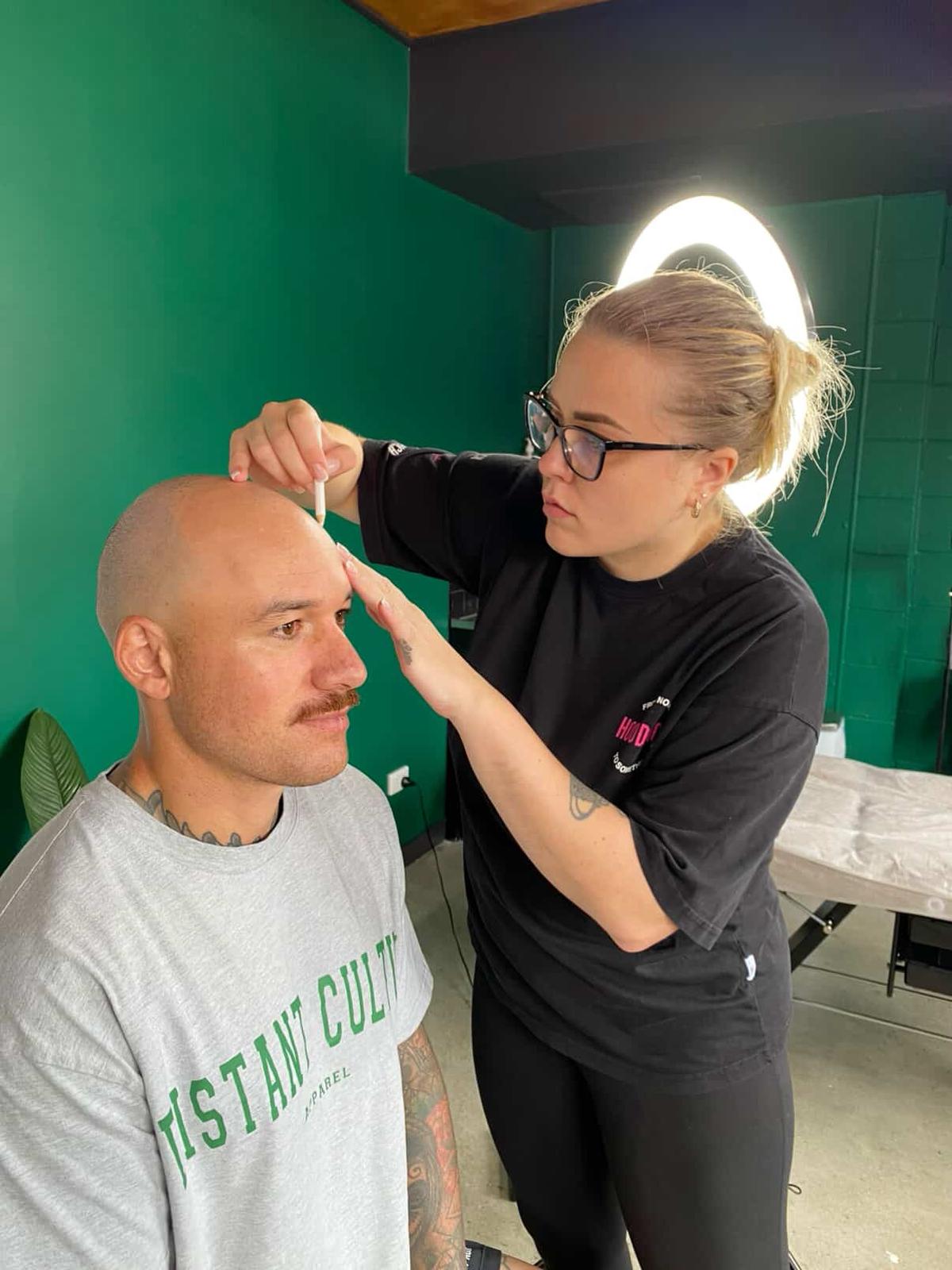 Uliana designing a client's SMP hairline before treatment